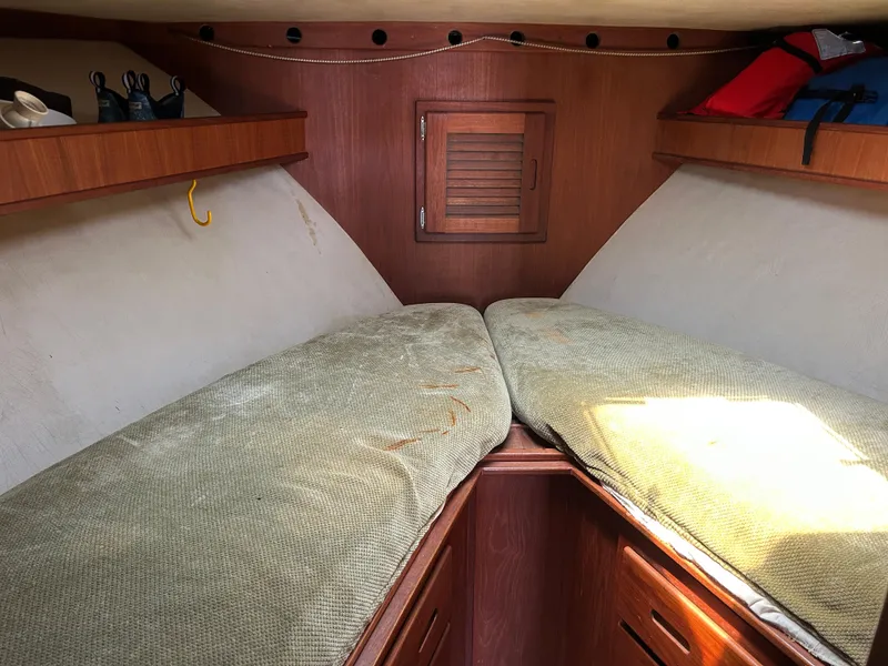Slide: The Image of 1990 Albemarle 325 Convertible cabin interior with twin beds and wooden storage. - 15