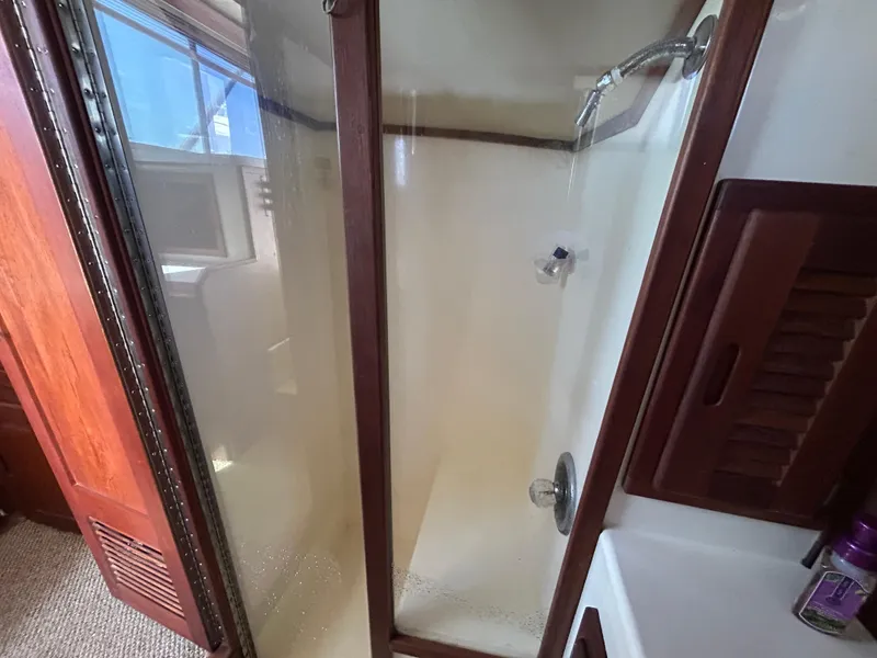 Slide: The Image of Shower area inside a 1990 Albemarle 325 Convertible boat, featuring wooden accents. - 17