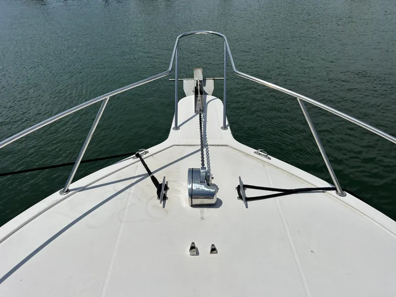 Slide: The Image of Bow of 1990 Albemarle 325 Convertible boat with anchor chain on calm water. - 22