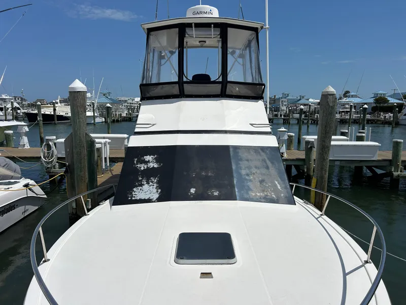 Slide: The Image of 1990 Albemarle 325 Convertible boat docked at marina under clear blue sky. - 23