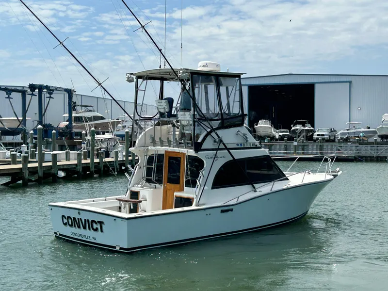 Slide: The Image of 1990 Albemarle 325 Convertible boat docked at marina with fishing rods. - 5