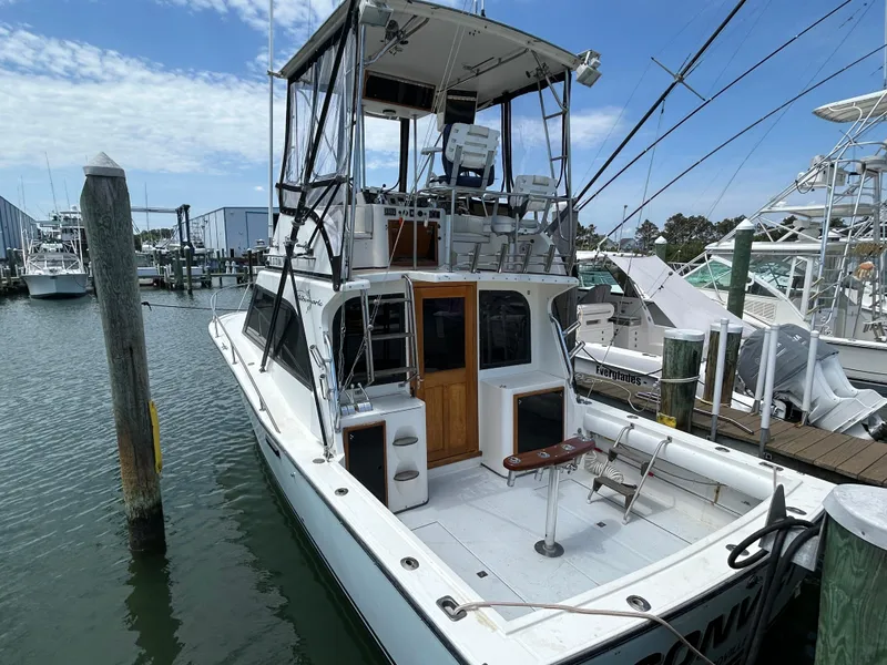 Slide: The Image of 1990 Albemarle 325 Convertible boat docked at marina, featuring flybridge and spacious deck. - 6