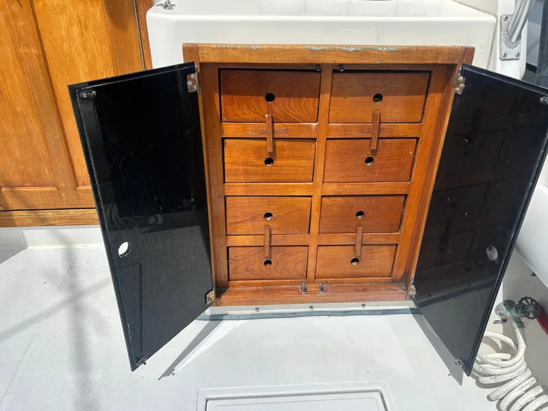 Slide: The Image of Wooden storage cabinet with open black doors on a 1990 Albemarle 325 Convertible boat. - 8