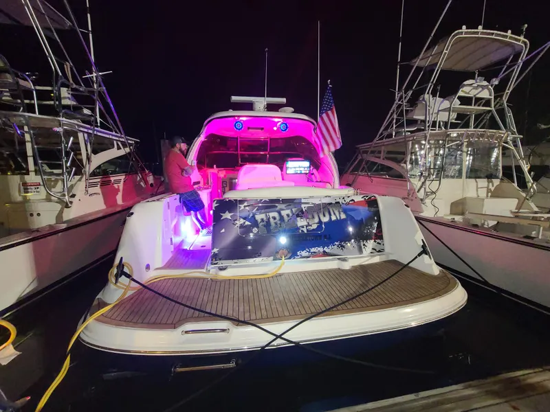 Slide: The Image of 2004 Sea Ray 390 Sundancer yacht docked at night with vibrant lighting. - 10