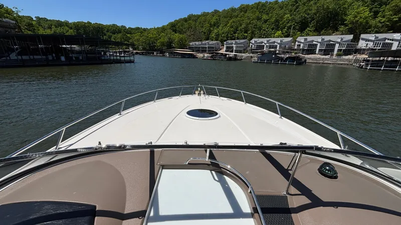 Slide: The Image of 2005 Regal 3350 Sport Cruiser on a serene lake with waterfront homes. - 18