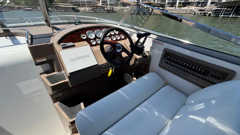 Slide: The Image of 2005 Regal 3350 Sport Cruiser helm with Garmin navigation, luxurious seating, and waterfront view. - 24