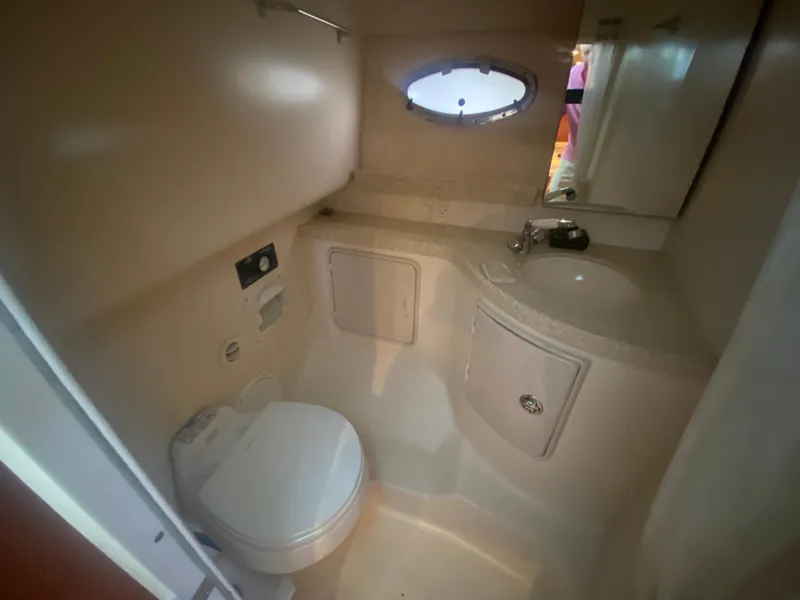 Slide: The Image of 2005 Regal 3350 Sport Cruiser bathroom with toilet, sink, and porthole window. - 41