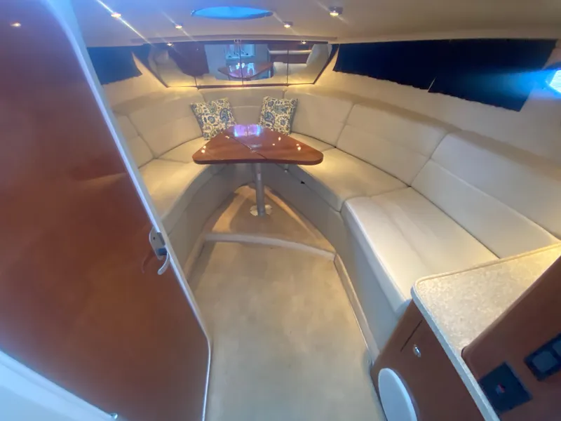 Slide: The Image of 2005 Regal 3350 Sport Cruiser interior with cozy seating and elegant wooden table. - 42