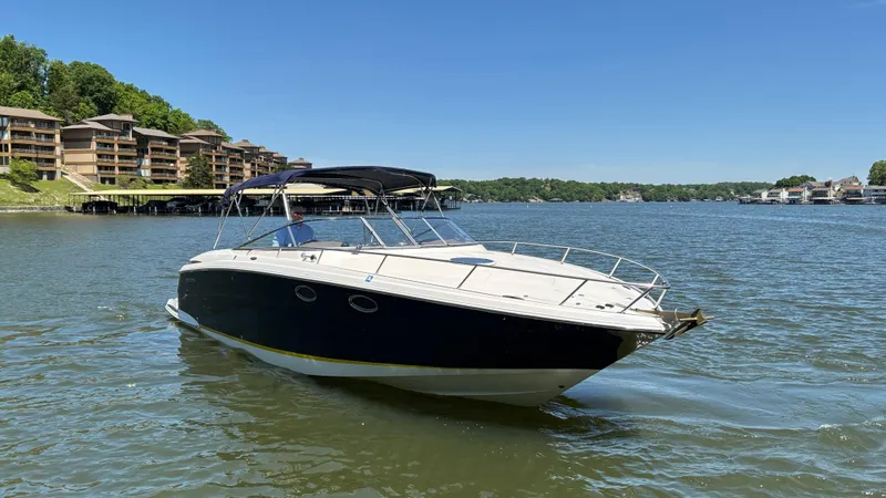 Slide: The Image of 2005 Regal 3350 Sport Cruiser on a scenic lake with waterfront buildings. - 5