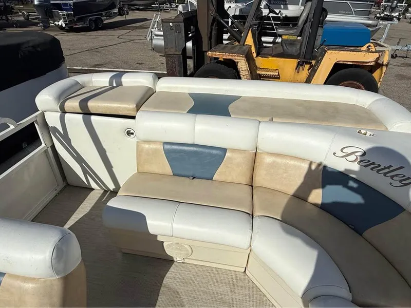 Slide: The Image of 2008 Bentley Pontoons 180 CRUISE interior with beige and blue seating in a marina setting. - 12