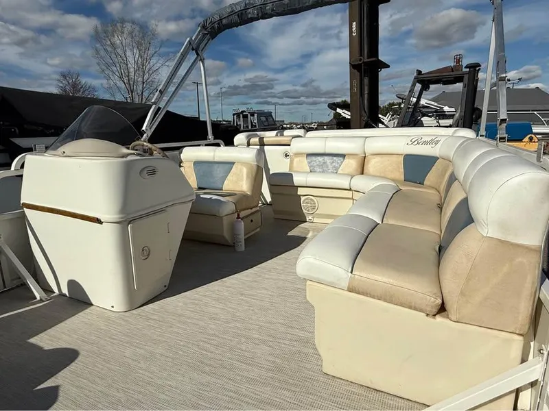 Slide: The Image of 2008 Bentley Pontoons 180 CRUISE with beige seating and helm, docked under a blue sky. - 13