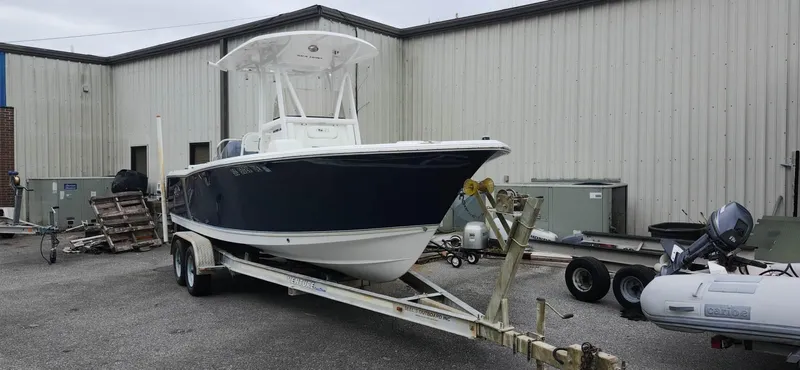 Slide: The Image of 2016 Sea Hunt Ultra 225 boat on trailer, parked outside industrial building. - 0