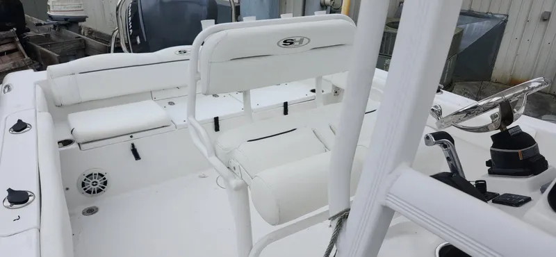 Slide: The Image of 2016 Sea Hunt Ultra 225 boat interior with white seating and steering console. - 3