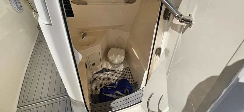 Slide: The Image of 2019 Cobia 280 Center Console boat bathroom with sink and toilet. - 12