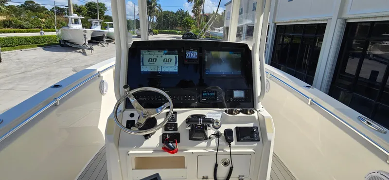 Slide: The Image of 2019 Cobia 280 Center Console boat dashboard with steering wheel and navigation screens. - 19