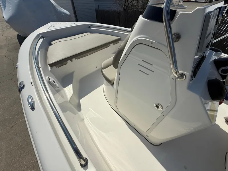 Slide: The Image of 2021 Key West 189 FS boat interior with seating and console, featuring sleek design and stainless steel rails. - 14