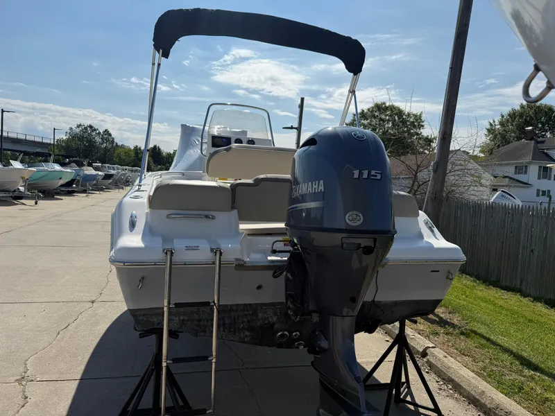 Slide: The Image of 2021 Key West 189 FS boat with Yamaha 115 engine, parked outdoors. - 2