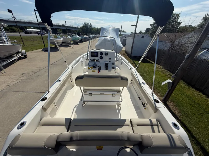 Slide: The Image of 2021 Key West 189 FS boat with canopy, beige seating, and control console, docked outdoors. - 6