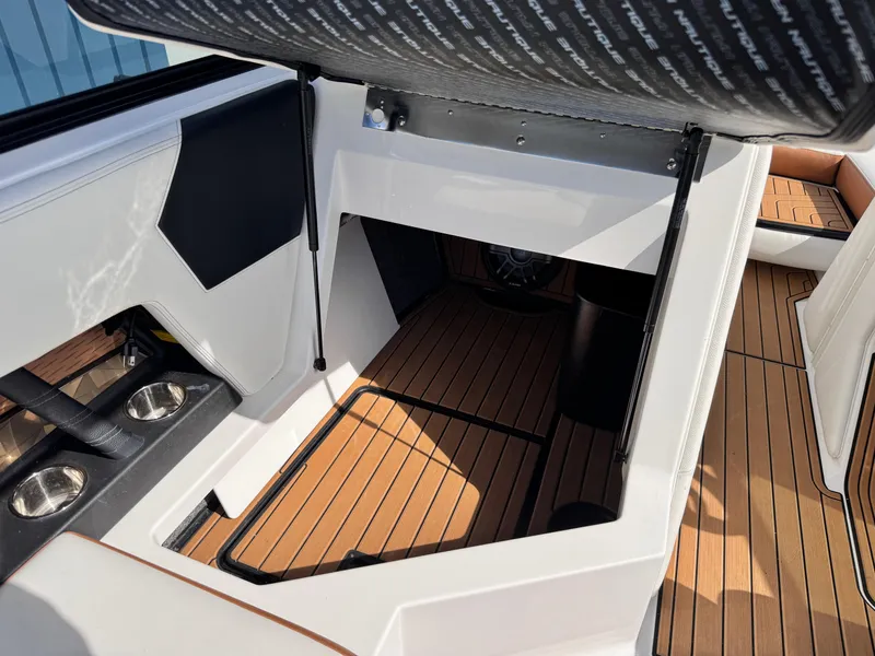 Slide: The Image of 2022 Nautique Super Air Nautique G21 interior with teak flooring and cup holders. - 20