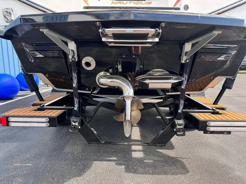 Slide: The Image of 2022 Nautique Super Air Nautique G21 boat stern with propeller and exhaust system. - 21