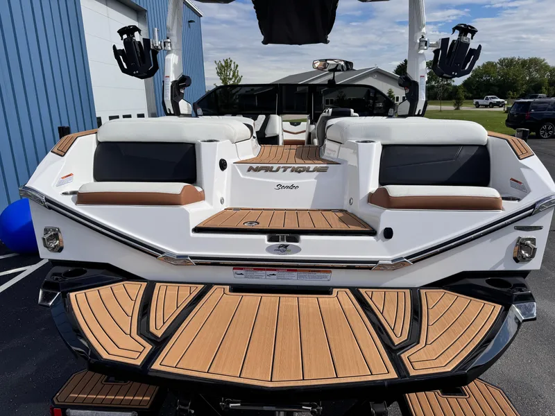Slide: The Image of 2022 Nautique Super Air Nautique G21 boat with teak deck, parked outdoors. - 22