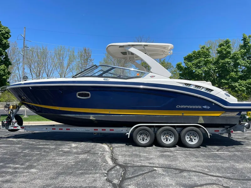 Slide: The Image of 2017 Chaparral 307 SSX boat on trailer, blue and white design, parked outdoors. - 0