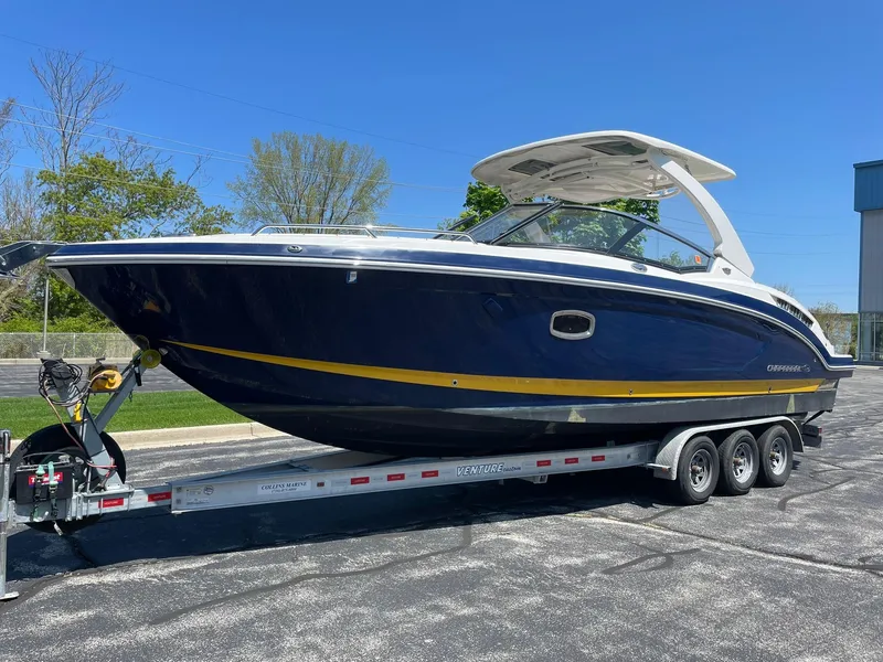 Slide: The Image of 2017 Chaparral 307 SSX boat on a trailer, parked outdoors under clear blue sky. - 1