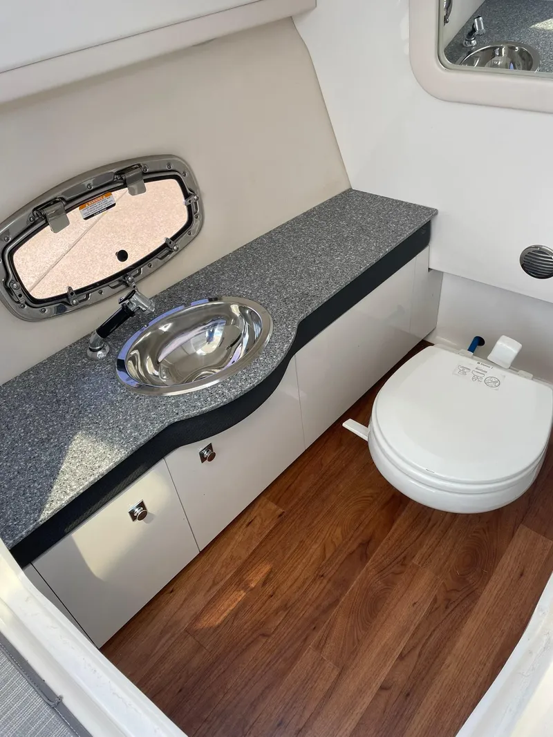Slide: The Image of 2017 Chaparral 307 SSX boat bathroom with sink, toilet, and wood flooring. - 17