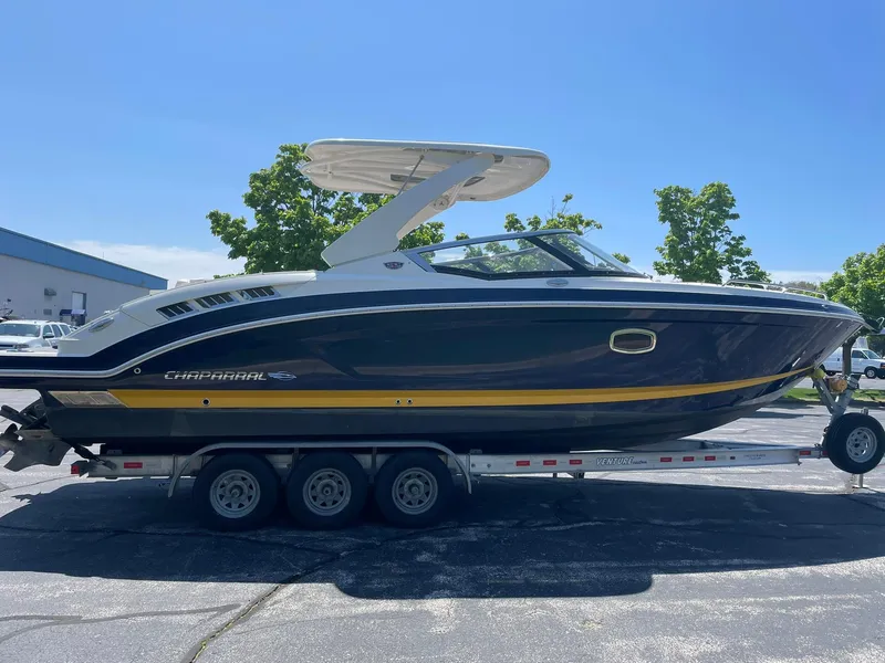 Slide: The Image of 2017 Chaparral 307 SSX boat on trailer, parked outdoors under clear blue sky. - 3