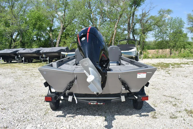 Slide: The Image of 2025 Lowe Outlet 20 boat on trailer, parked outdoors with trees in background. - 5