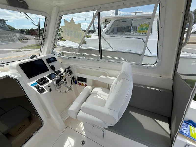 Slide: The Image of Interior of 2024 NorthCoast 235 HT boat, featuring helm and seating area. - 10