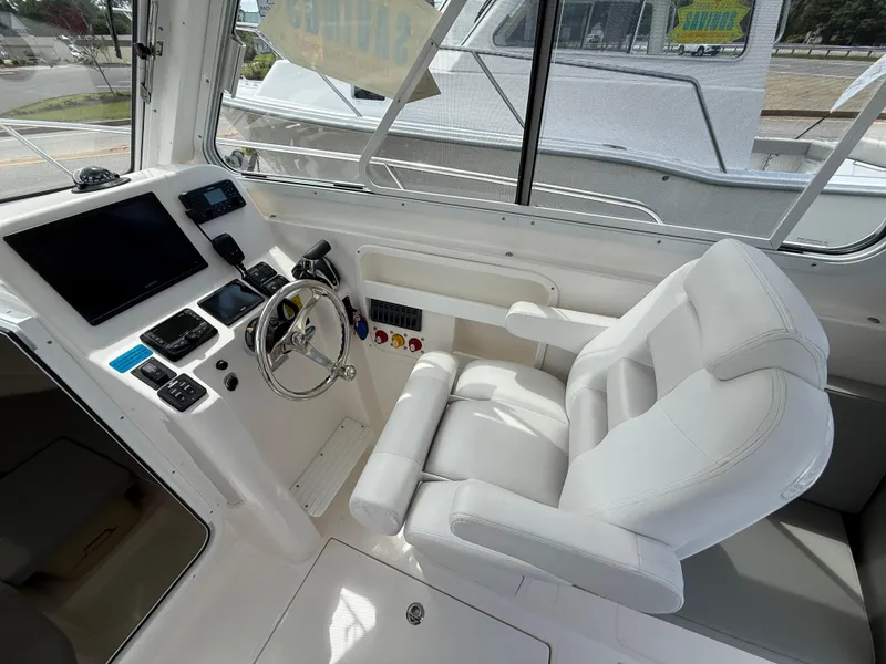 Slide: The Image of 2024 NorthCoast 235 HT boat interior with modern helm and comfortable captain's chair. - 11