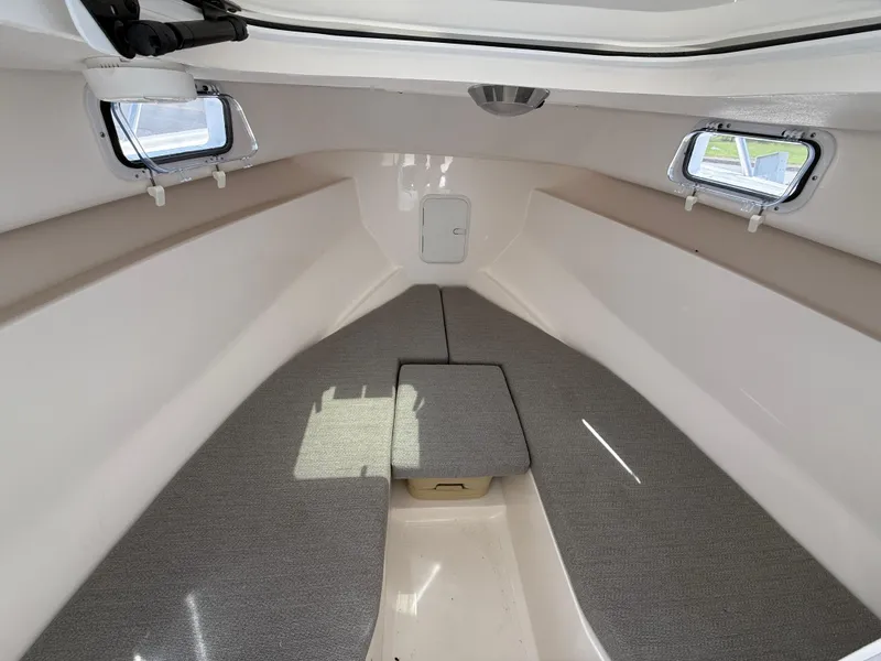 Slide: The Image of 2024 NorthCoast 235 HT cabin interior with gray cushions and side windows. - 14