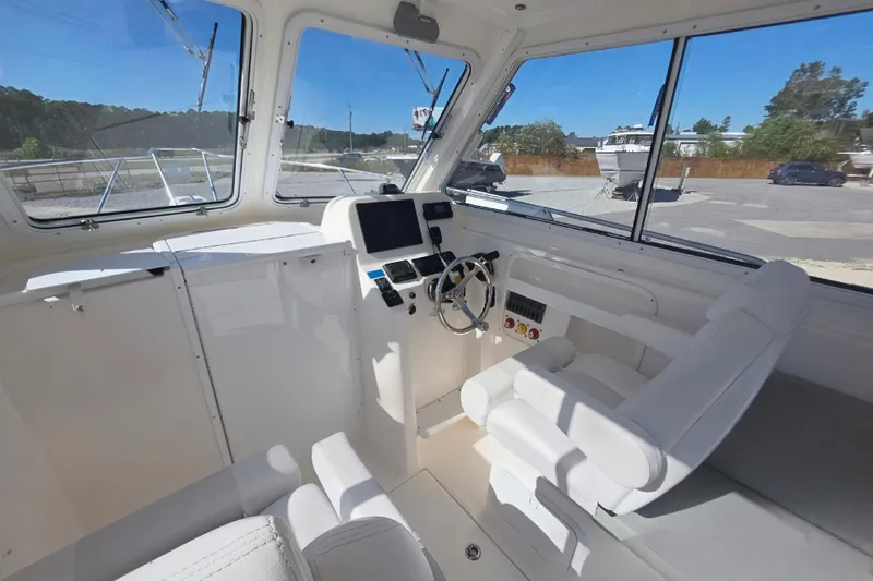 Slide: The Image of 2024 NorthCoast 235 HT boat interior with helm, steering wheel, and navigation equipment. - 19