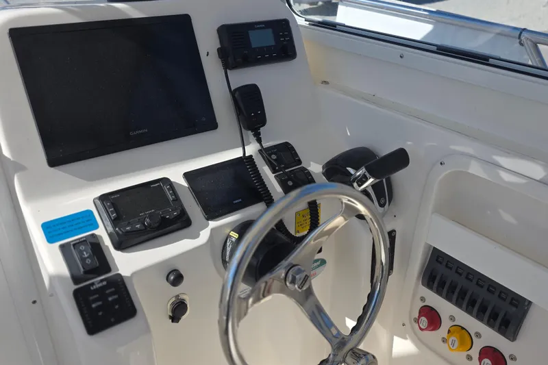 Slide: The Image of 2024 NorthCoast 235 HT boat helm with Garmin electronics and steering wheel. - 23