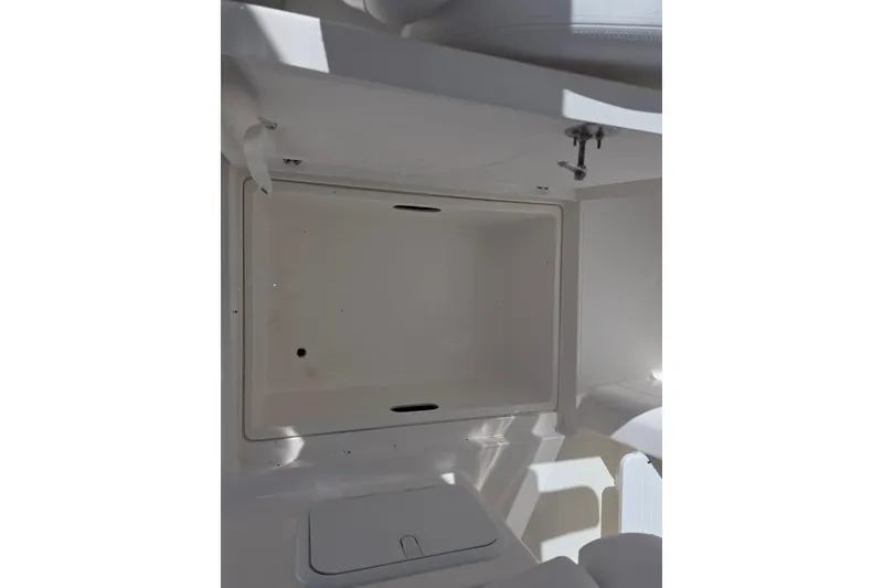 Slide: The Image of 2024 NorthCoast 235 HT boat interior storage compartment, white and spacious design. - 24