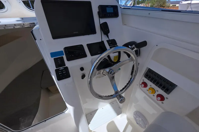 Slide: The Image of 2024 NorthCoast 235 HT boat helm with steering wheel and control panel. - 30