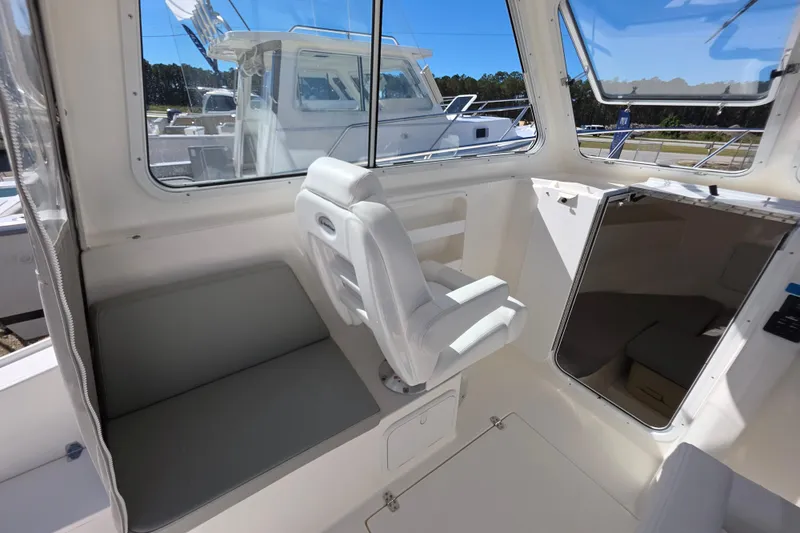 Slide: The Image of 2024 NorthCoast 235 HT boat interior with seating and cabin access. - 34