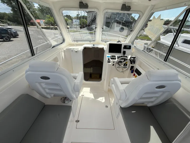 Slide: The Image of 2024 NorthCoast 235 HT boat interior with helm, seating, and navigation equipment. - 8
