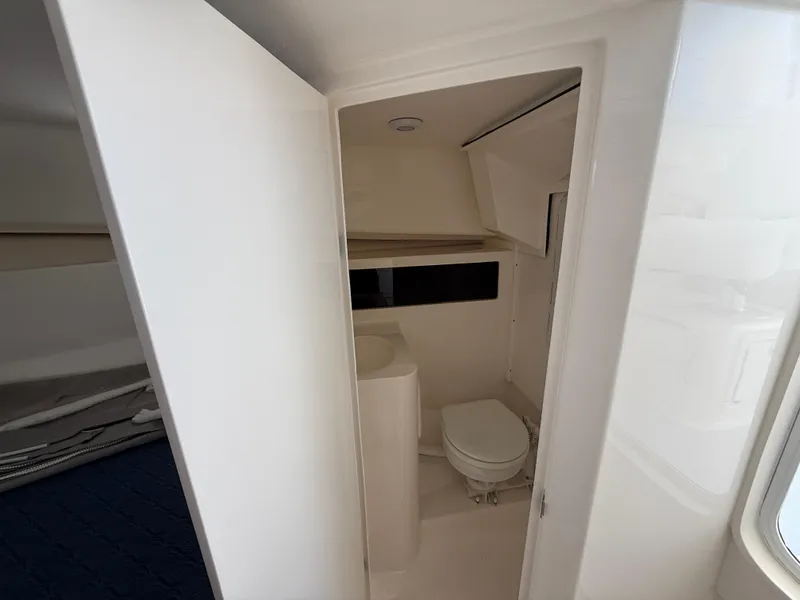 Slide: The Image of 2025 NorthCoast 255 HT boat interior bathroom with toilet and sink. - 12