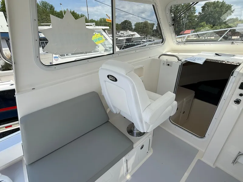 Slide: The Image of Interior of 2025 NorthCoast 255 HT boat with seating and steering console. - 6