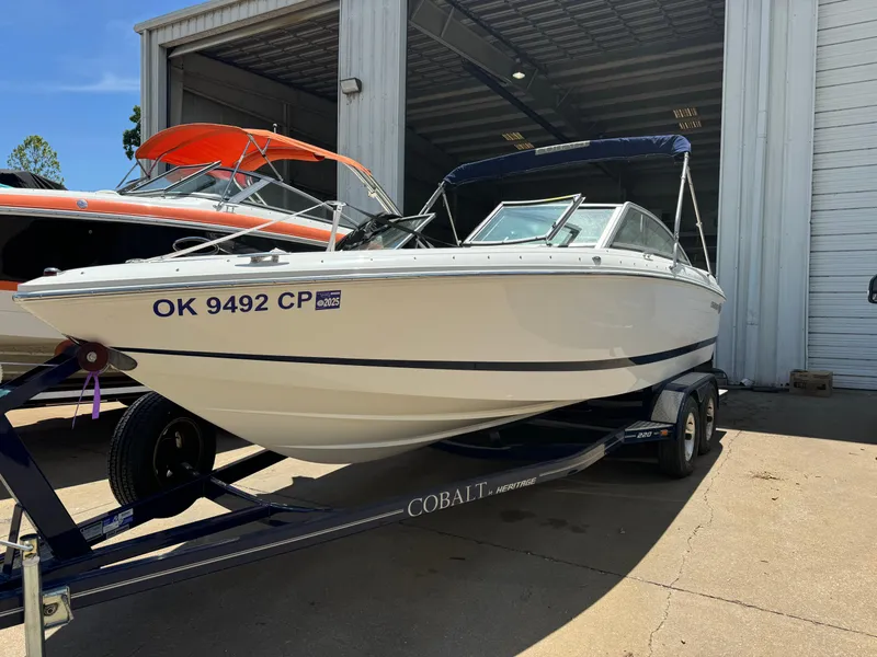 Slide: The Image of 2008 Cobalt 230 boat on trailer, parked outside a garage. - 1