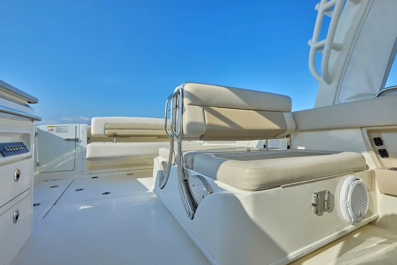 Slide: The Image of 2016 Boston Whaler 320 Vantage boat interior with cushioned seating and clear blue sky. - 11
