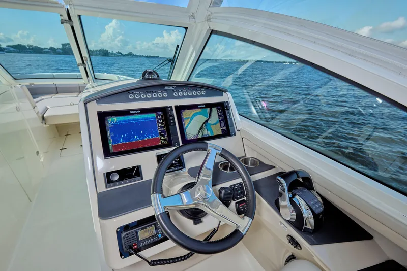 Slide: The Image of Cockpit of 2016 Boston Whaler 320 Vantage with navigation screens, steering wheel, and ocean view. - 17