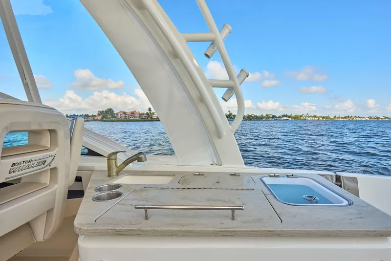 Slide: The Image of Boston Whaler 320 Vantage 2016 boat with outdoor sink and countertop, overlooking serene water. - 20