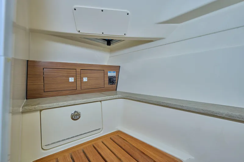 Slide: The Image of Interior cabin of 2016 Boston Whaler 320 Vantage with wood accents and storage compartments. - 22