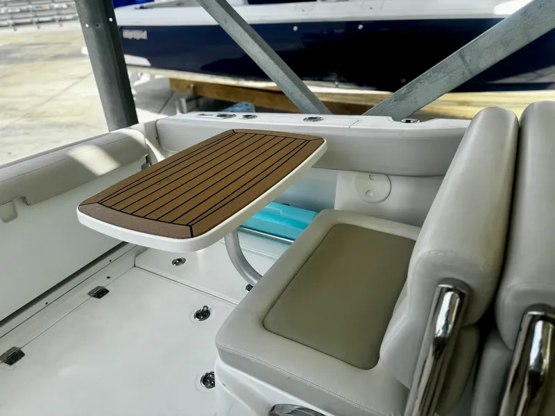 Slide: The Image of 2016 Boston Whaler 320 Vantage interior with wooden table and cushioned seating. - 30
