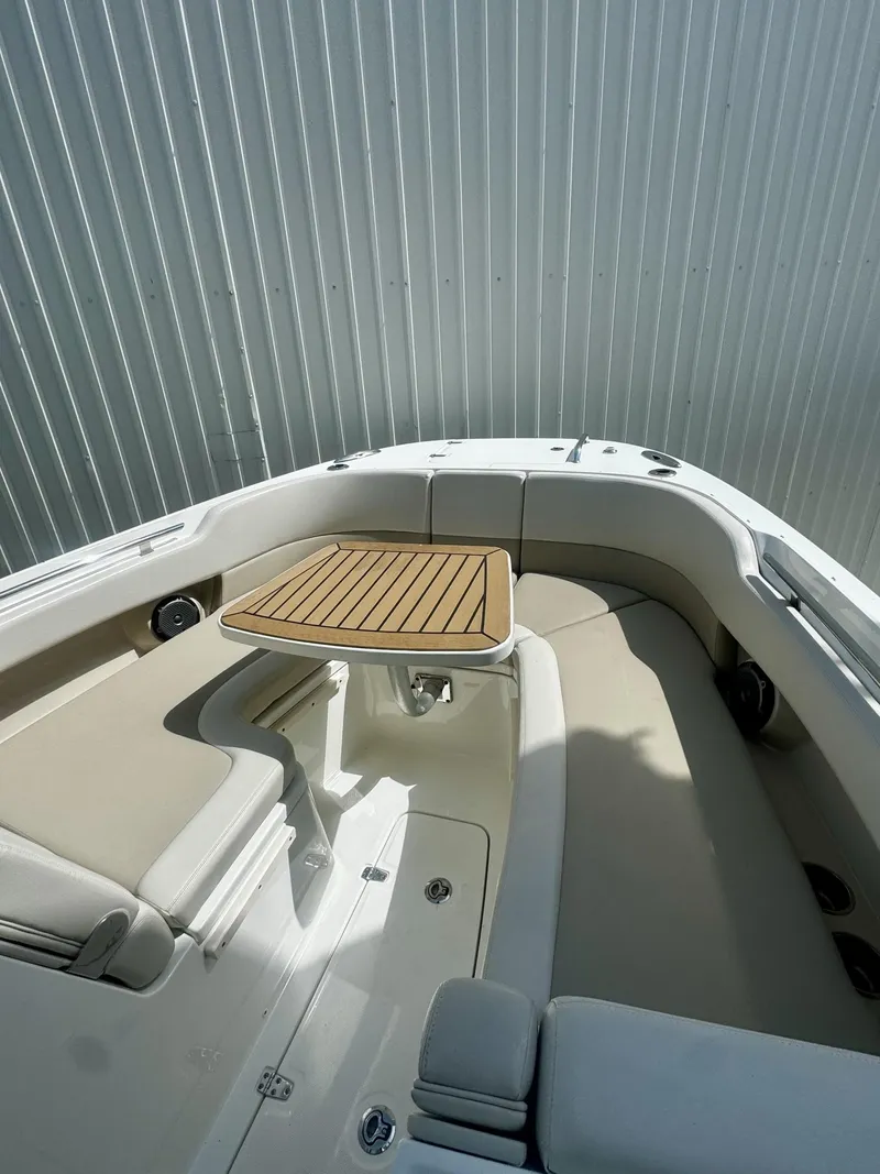 Slide: The Image of 2016 Boston Whaler 320 Vantage boat interior with seating and wooden table. - 31