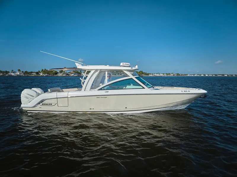 Slide: The Image of 2016 Boston Whaler 320 Vantage boat cruising on open water under clear blue sky. - 32
