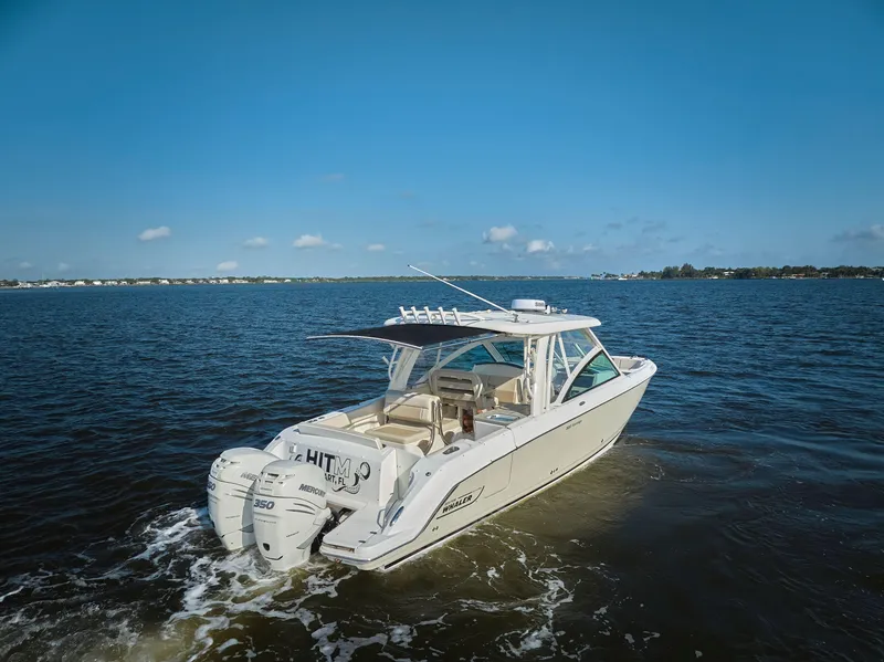 Slide: The Image of 2016 Boston Whaler 320 Vantage cruising on open water under clear blue skies. - 33